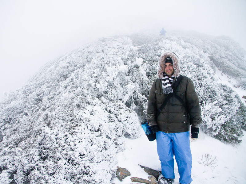 Nick Kembel standing on a snowy mountain peak in Taiwan in full winter gear