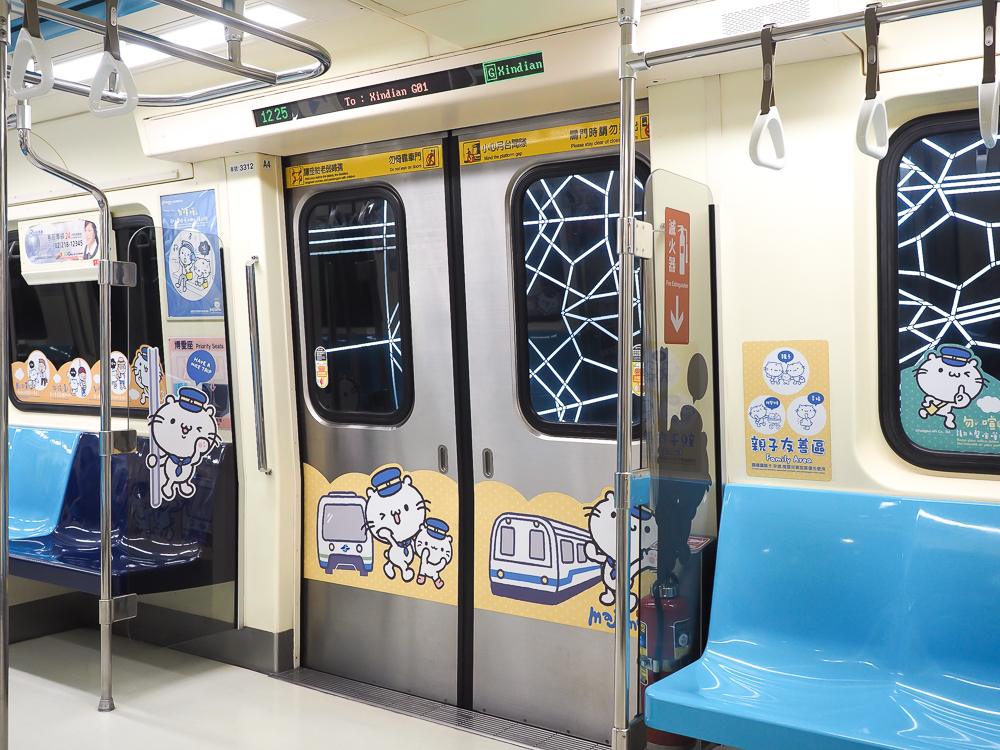 The inside doors of an MRT in Taipei, with cat stickers on the walls