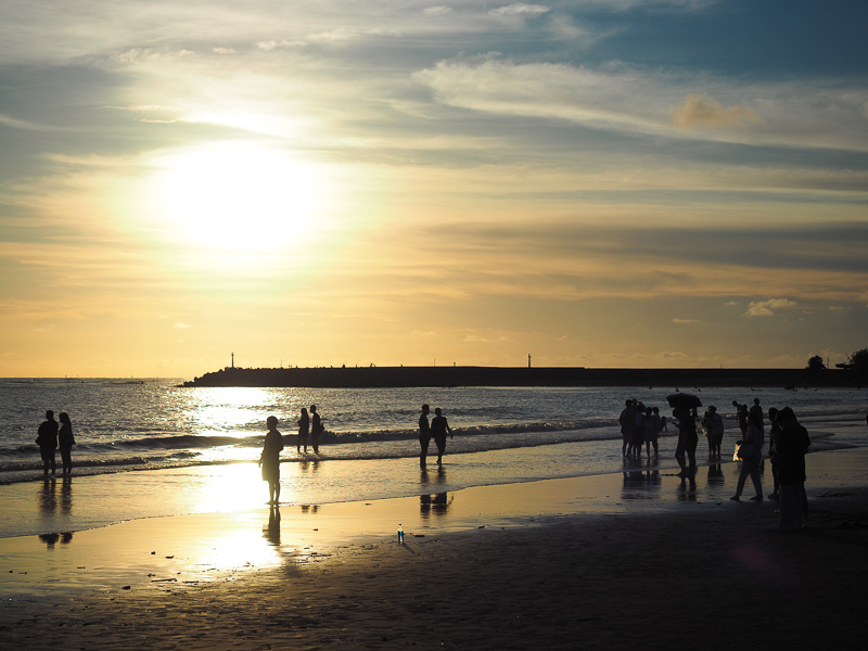 Sunset at Yuguang Beach in Tainan, with people walking on the beach