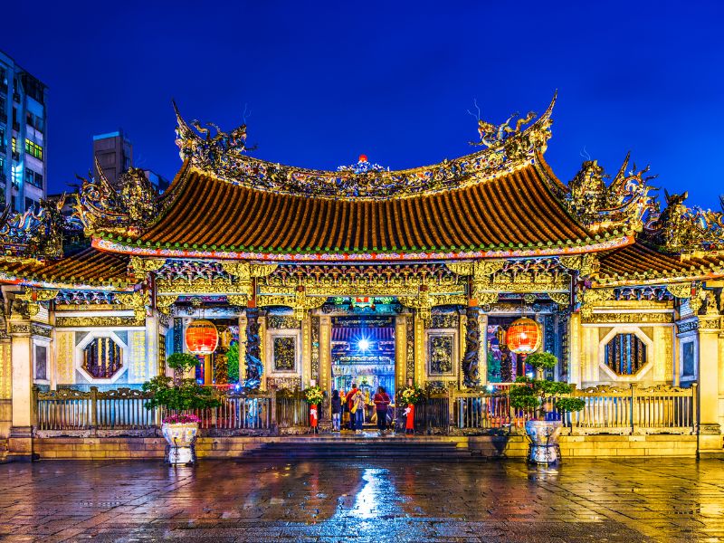 A traditional Taiwanese temple and square in front of it at night