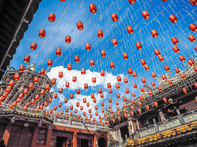 Looking up at red lanterns hanging above the courtyard of Lukang Tianhou Temple, with blue sky above