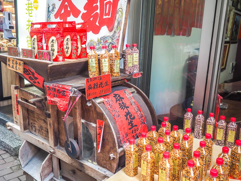 An old wooden food cart with plastic bottles of roasted peanuts, a traditional snack in Changhua