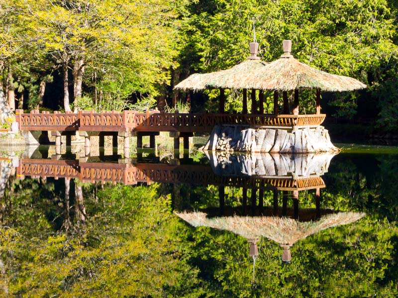 A traditional pavilion reflecting in the water of a pond