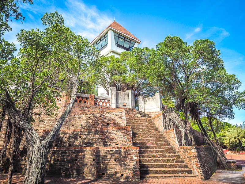 Looking up at the stairs of an old Dutch fort in Tainan with trees on the sides