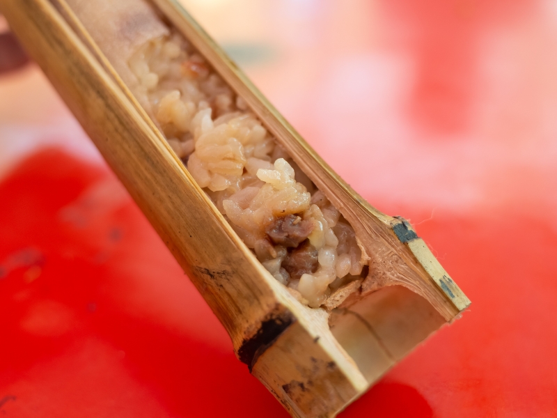 Close up of a tube of bamboo stuffed with sticky rice