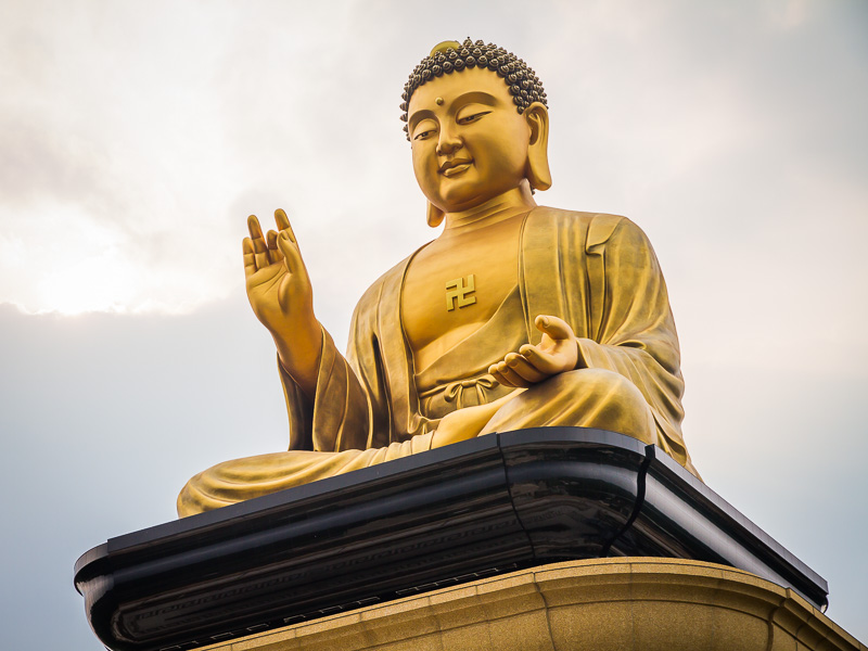 A giant golden statue of a seated Buddha