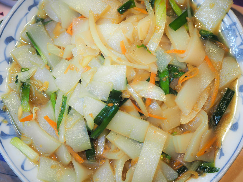 Close up from above of a dish of wide rice noodles, or Hakka bantiao noodles
