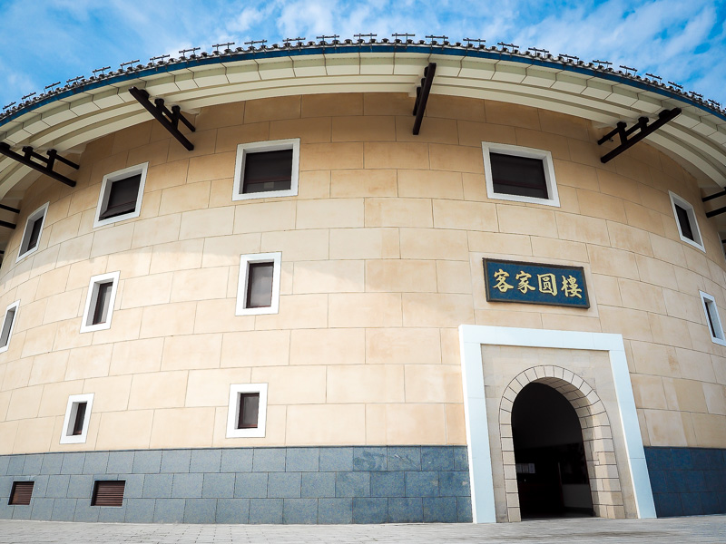A large round gray and white building in the style of a Hakka roundhouse
