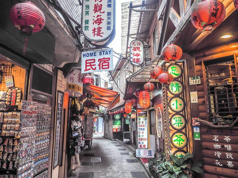 A narrow lane with some hotel signs and red lanterns in Jiufen, New Taipei City