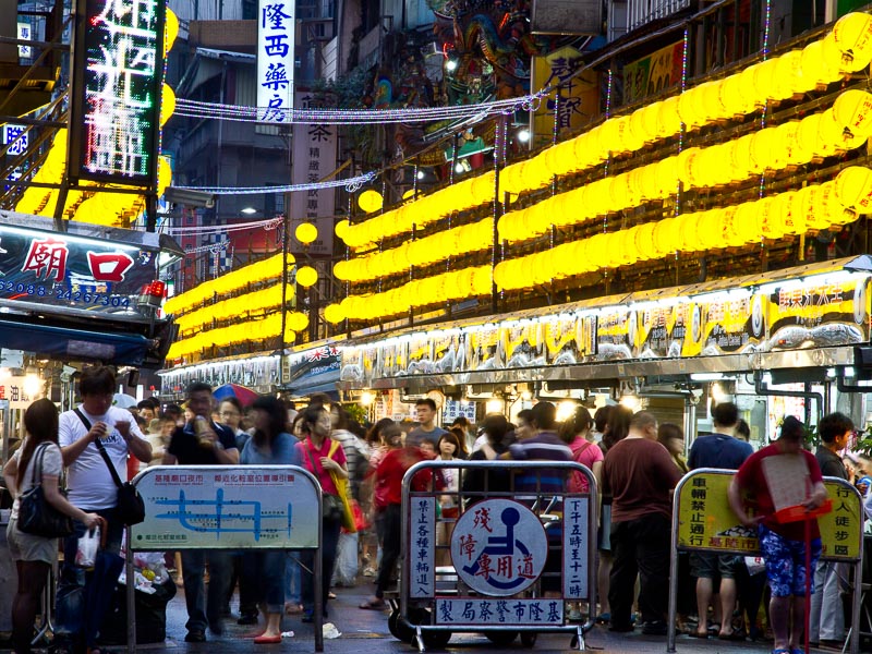 Rows of yellow lanterns above crowds in Keelung Night Market