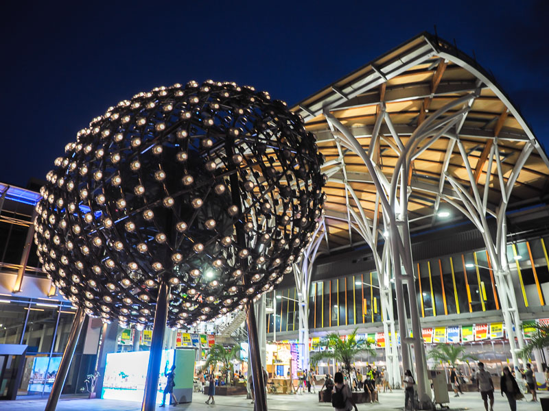 A large egg-shaped light installation in front of Keelung Train Station at night