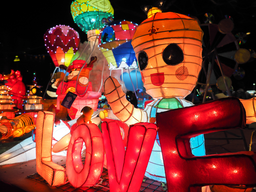 Some large, colorful lanterns shaped like people and the word LOVE