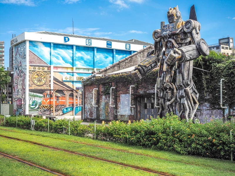 A giant transformer statue and mural of Kaohsiung train station 