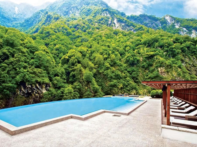 A swimming pool with misty mountains in the background