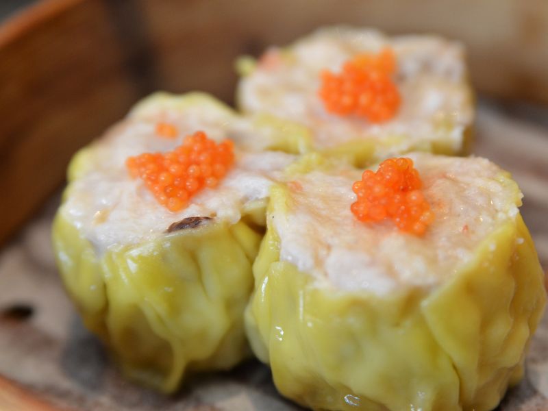 Close up of steamed shumai dim sum in a bamboo basket