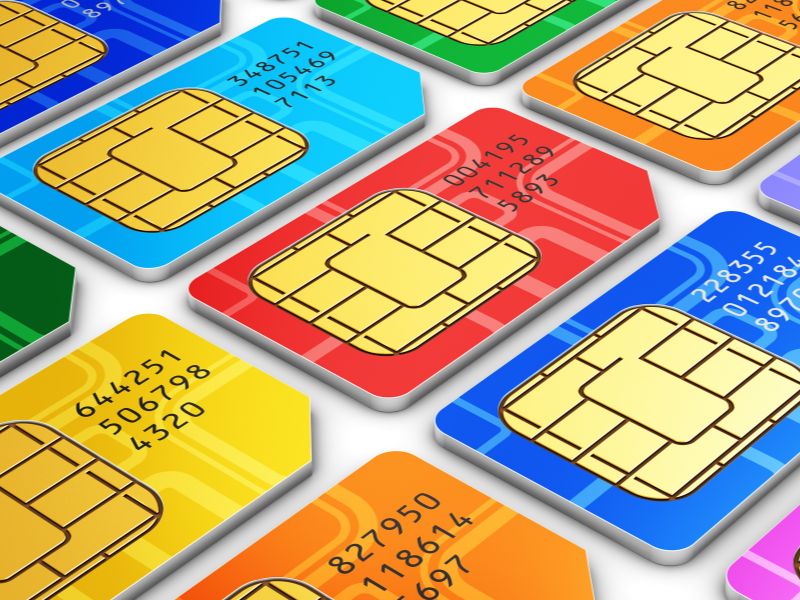 Several different colored SIM cards laid out on a flat white surface