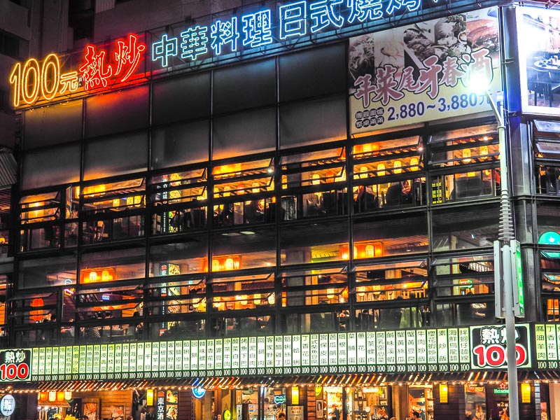 A giant restaurant building with menu printed in Chinese on placards on the outside