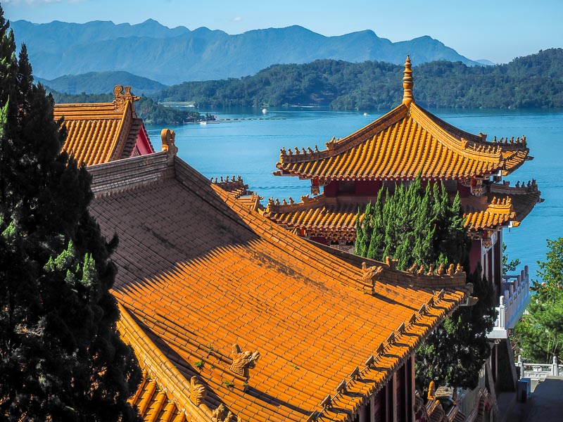 The orange roofs of a large temple with Sun Moon Lake in the background