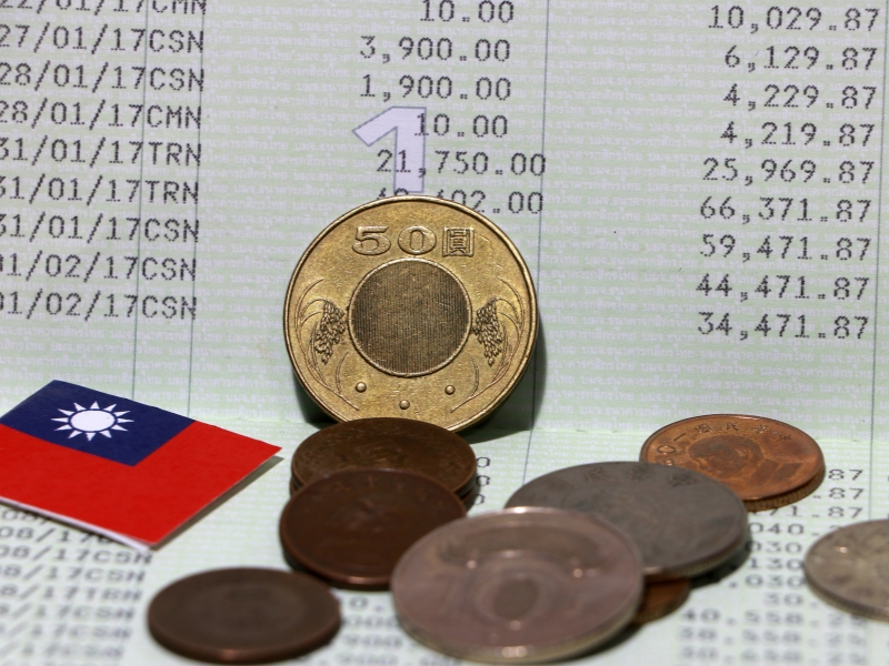 A small Taiwanese flag and some Taiwan coins on a Taiwan bankbook page