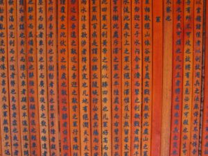 Vertical rows of orange sticks with Mandarin characters written on them